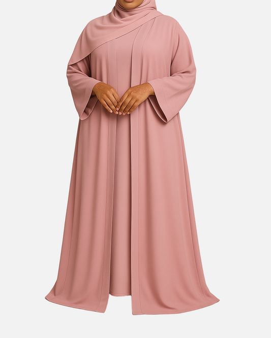 Woman wearing a pink abaya against a beige background