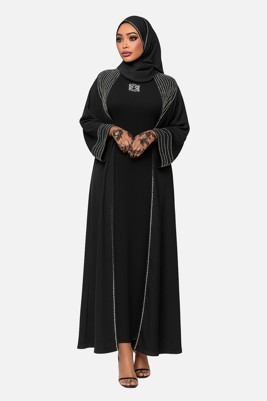Woman wearing a black abaya with white embroidery on a white background