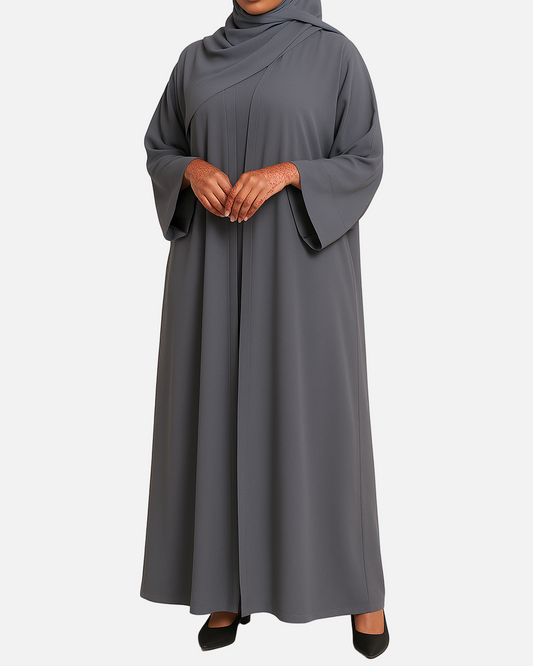 Woman wearing a gray abaya and hijab on a beige background